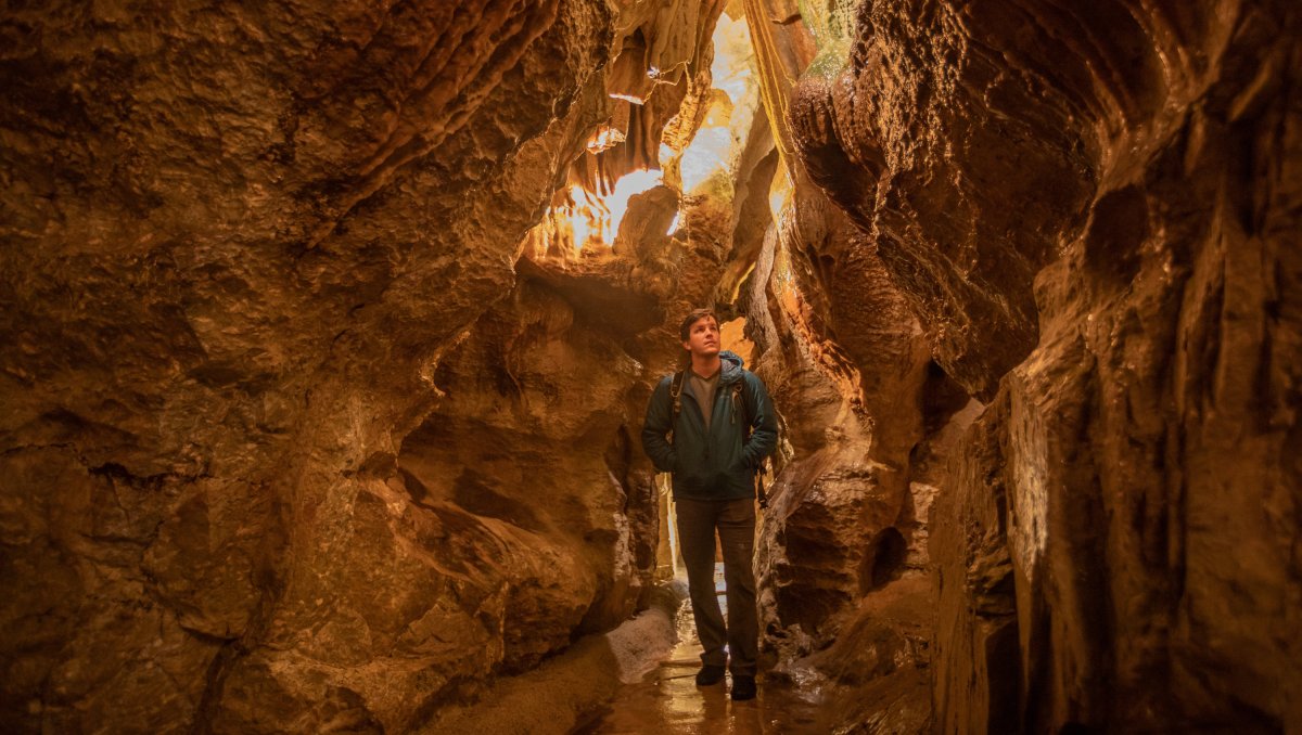 Man walking in brightly lit cavern