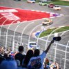 Fans cheering on NASCAR race at Charlotte Motor Speedway.