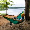 Man sitting in hammock, sipping coffee and gazing out over Badin Lake in Uwharrie National Forest, North Carolina.
