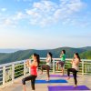 Women in yoga class overlooking mountains at Art of Living Retreat Center.