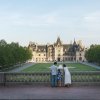 Family of 3 standing at stone wall overlooking Biltmore Estate and grounds.