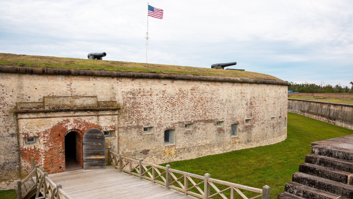 Exterior of Fort Macon with moat, bridge and cannons visible.