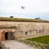 Exterior of Fort Macon State Park with fort, cannons and American flag visible.