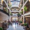 Interior of Grove Arcade in Asheville with stalls, people shopping, plants and interesting architecture.