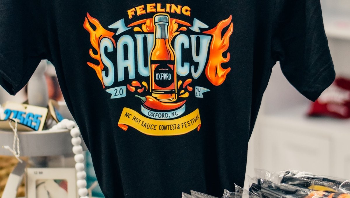 Black T-shirt with NC Hot Sauce Festival design at vendor's table.