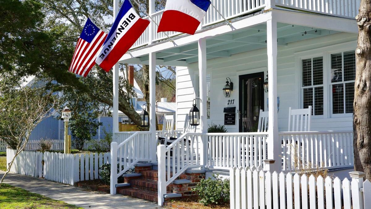 Inn on Turner's front porch with three flags blowing in wind from balcony.