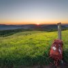 Backpack sitting against wooden post with sun rising over Appalachian Mountains at sunrise.
