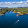Aerial of boat on Lake Norman with shore and land in distance.