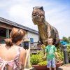Mother taking photo of excited child in front of T-Rex statue at NC Aquarium at Pine Knoll Shores.