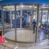 Person indoor skydiving with people observing.