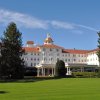 Exterior of Carolina Hotel at Pinehurst Resort with green lawn in foreground during daytime.