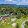 Aerial of Switzerland Inn's grounds with forest and Blue Ridge Mountains in background.